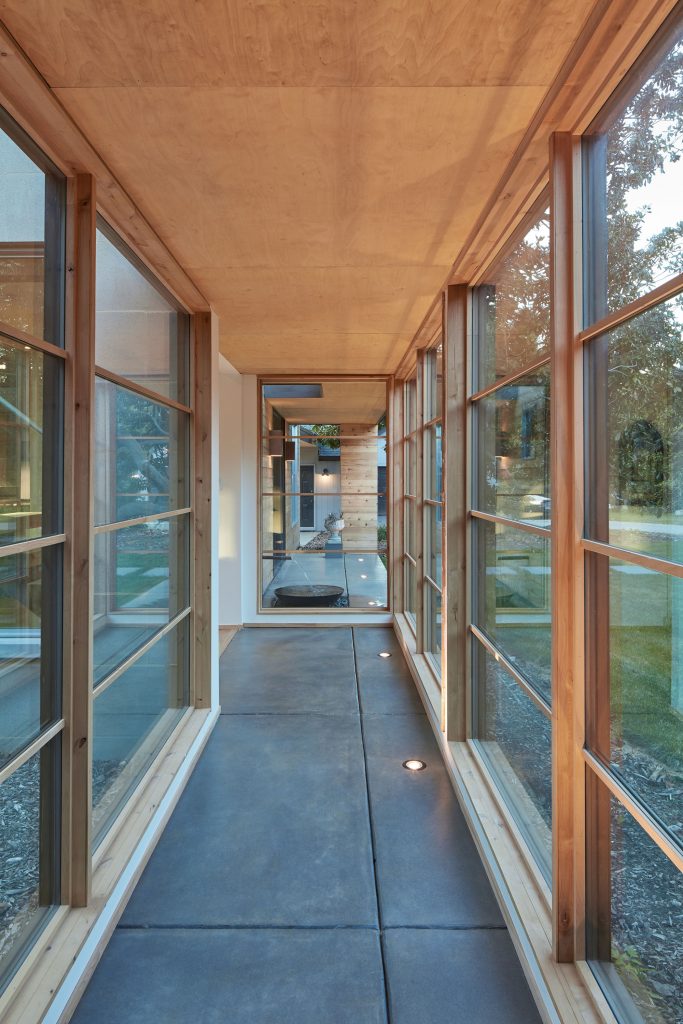 A gallery with runway lights, a birch ceiling, and concrete floor connects Marta Hansen’s architect studio to her son Wes’s house.