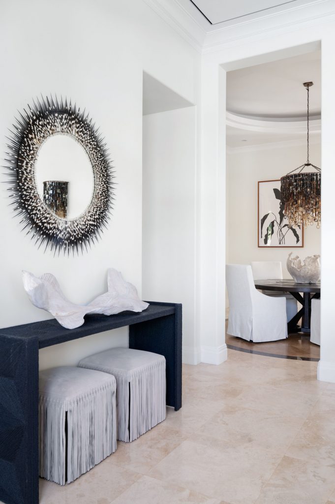 In the foyer, a porcupine quill mirror is juxtaposed with other organic forms; underneath the mirror is a table made of African sea-grass rope.