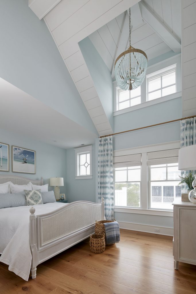 A vaulted ceiling with windows beckons  natural light into the generous bedroom.