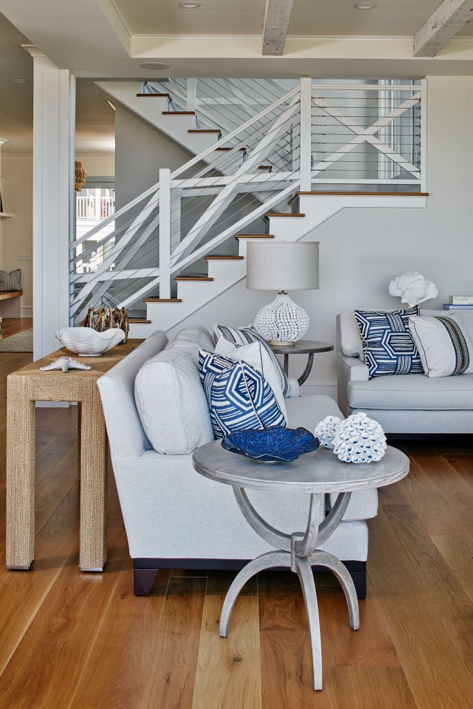 An unusual staircase is both modern and coastal, with nautical wiring and white woodwork recalling a lighthouse or lifeguard stand. 