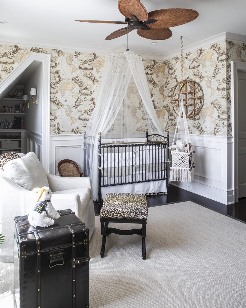 The nursery echoes the mood of an African safari, with khaki-colored linens, bamboo furniture chest, mosquito netting, and wallpaper featuring a world map. The crib was Alice’s when she was a baby.