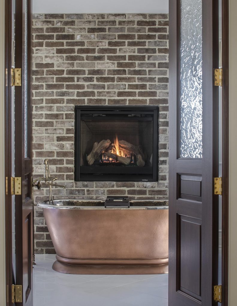 A specialty item in the master bath is the copper soaking tub situated in front of the brick wall, which continues the interior design’s subtext: an emphasis on comfort. 