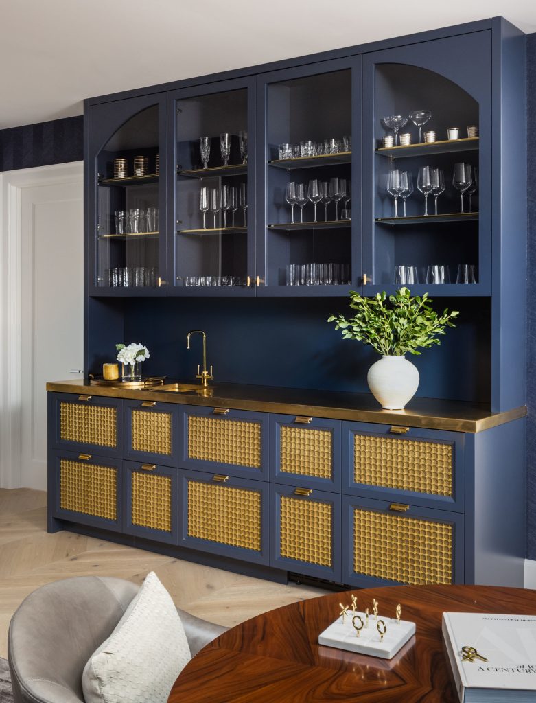 Bolder colors and strong furnishings, such as this blue-grey bar, enliven the interior. Photo by Jenn Verrier