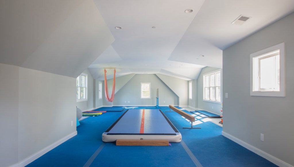 Space above the garage was converted to a gym equipped for two children  in training to be gymnasts.