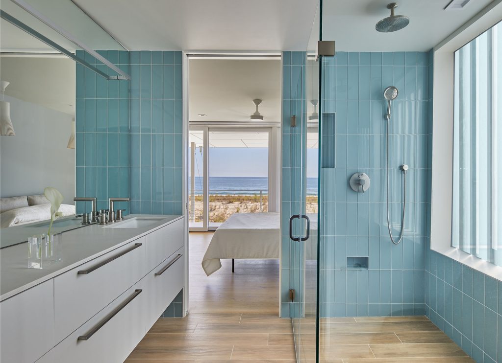 The primary bathroom, in watery hues of blue-green, has ocean views to ensure a constant connection with the sea. 