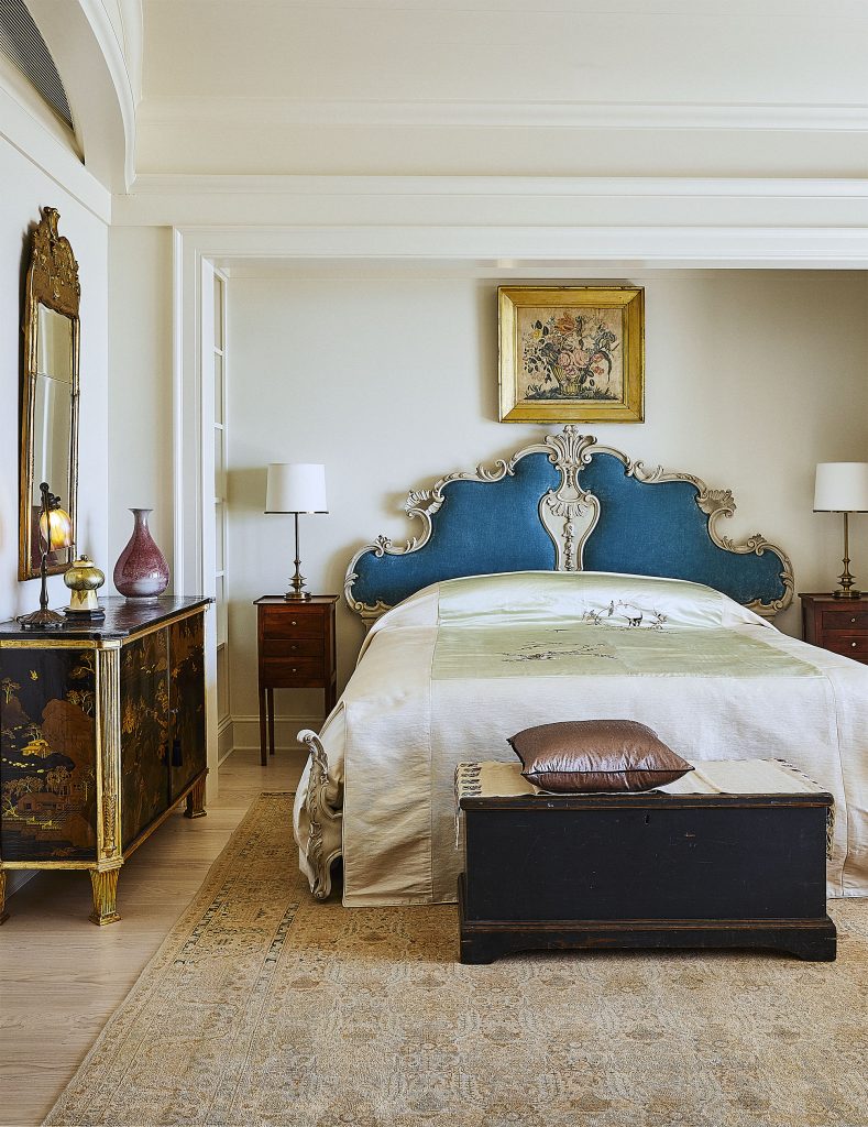 In the primary bedroom, a sky-blue headboard is accentuated by textiles on the bed and floor. 