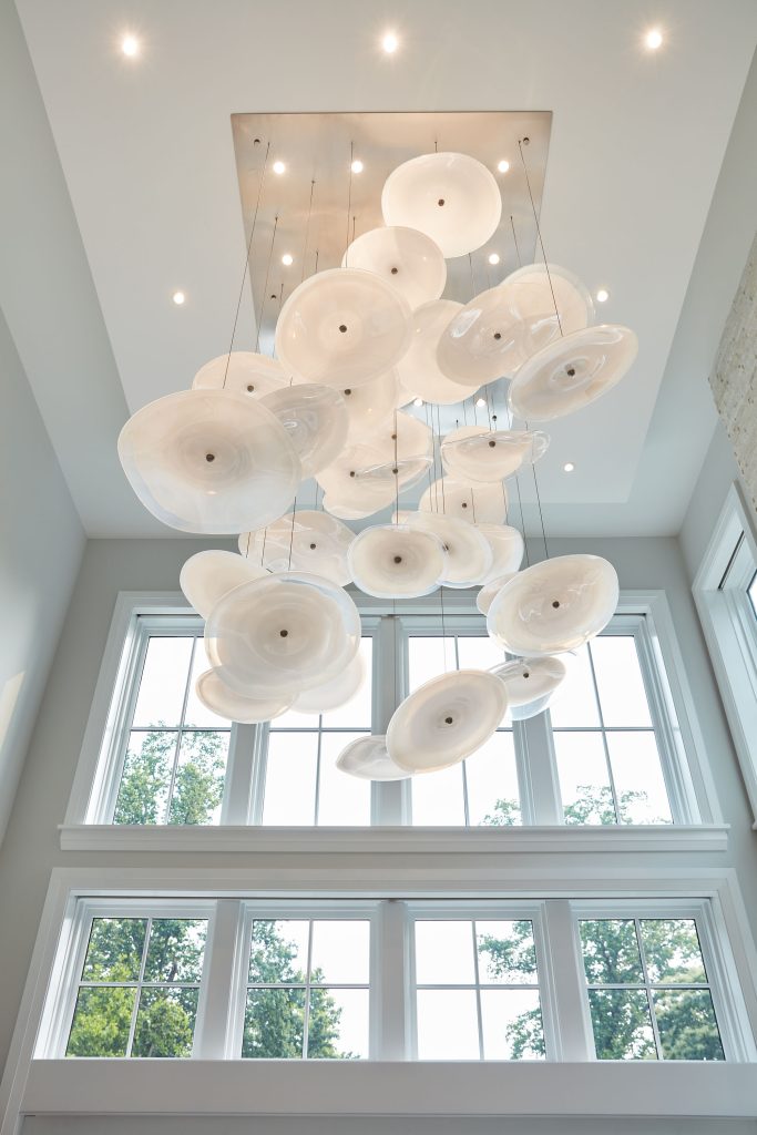 One of the stand-out pieces within the home is a custom 12-foot-tall light fixture with handmade blown glass disks that hang over the great room. It reminds homeowner Jeffrey Dawson of oyster shells, another homage to his extended Eastern Shore family, who were watermen.