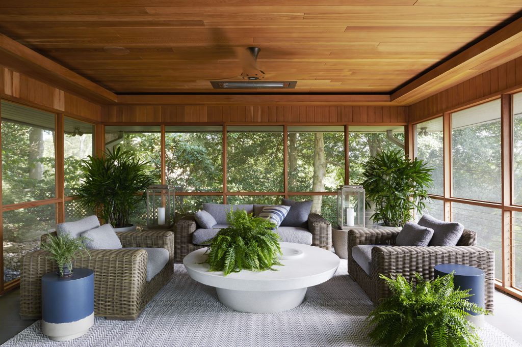 Patrick Sutton’s design team refurbished and refreshed the pre-existing screened porch. Generous sliding glass doors connect the two spaces. 
