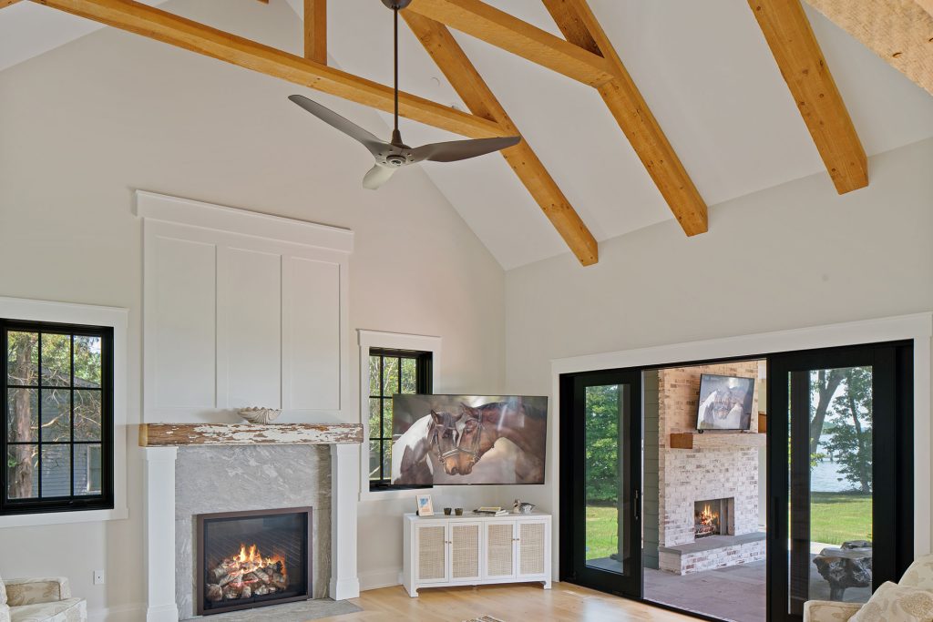 The timbers supporting  the roof, milled by Tucker  Hardwood, add warmth to the home’s cool white palette.