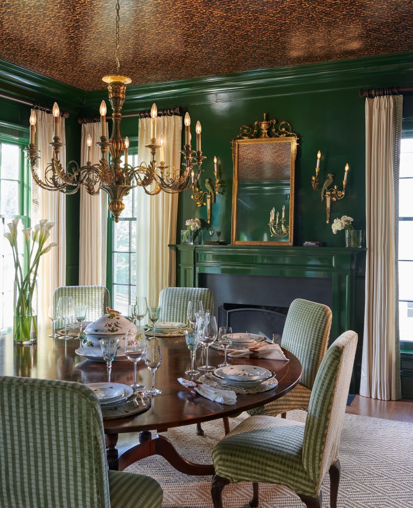 The formal dining room is done in dark green with tortoiseshell wallpaper on the ceiling.  Photo courtesy of Jennifer Tonkel.